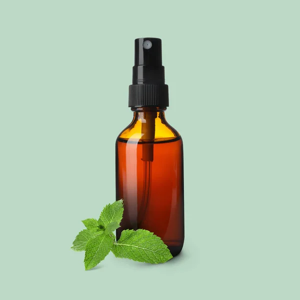 Eine Flasche Ätherisches Minzöl Und Blätter Auf Hellgrünem Hintergrund — Stockfoto