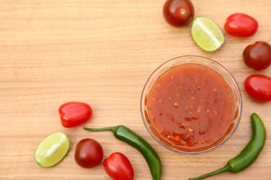 Lezzetli salsa sosunun düz kompozisyonu ve ahşap masanın üzerinde farklı malzemeler vardı. Metin için boşluk