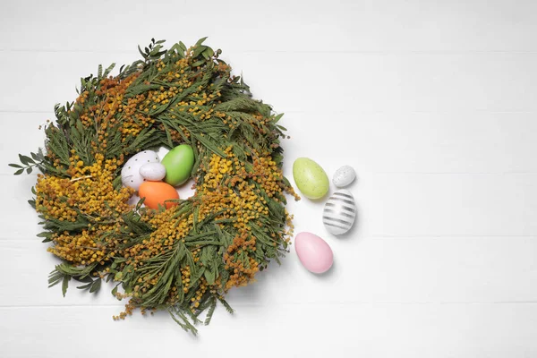 Festlich Geschmückte Ostereier Und Ein Nest Schöner Frühlingsblumen Auf Weißem — Stockfoto