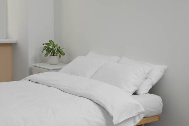 White soft pillows on cozy bed in room