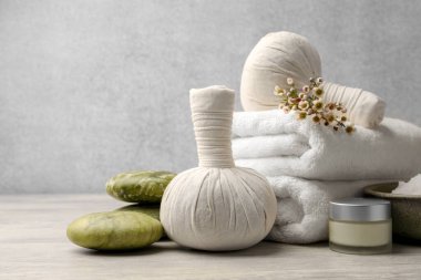 Composition with spa products and flowers on grey wooden table. Space for text