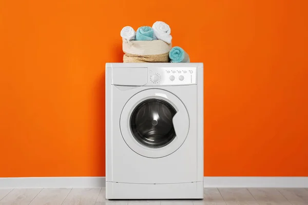 Mesin Cuci Dengan Handuk Bersih Dekat Dinding Oranye Dalam Ruangan — Stok Foto