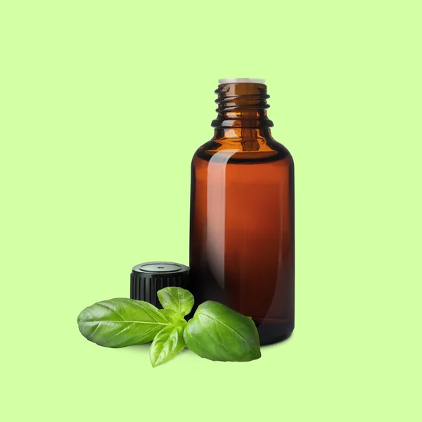 Eine Flasche Ätherisches Basilikumöl Und Blätter Auf Hellgrünem Hintergrund — Stockfoto
