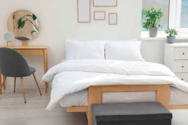 Sıcak oda içinde yumuşak beyaz yastıklı yatak