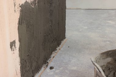 Kapıdaki duvara fayans yerleştirmek için yapıştırıcı karışımı