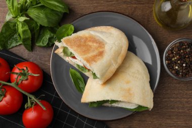 Mozarella, domates ve fesleğenli nefis pita sandviçleri ahşap masada, düz yerde.