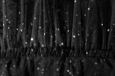 Arkaplanı parlak yıldızlar olan güzel siyah tül kumaş, yakın plan.