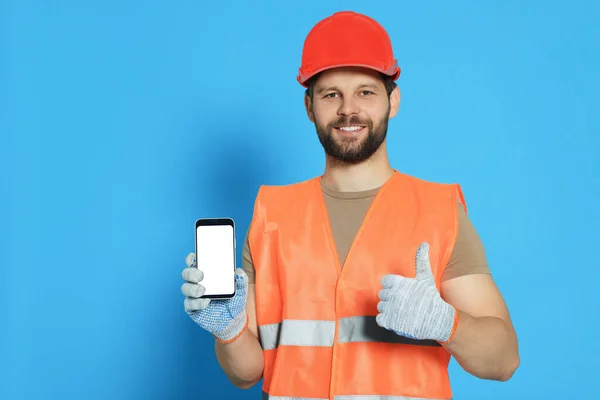 Man Reflective Uniform Showing Smartphone Thumbs Light Blue Background Space — Stock Photo, Image