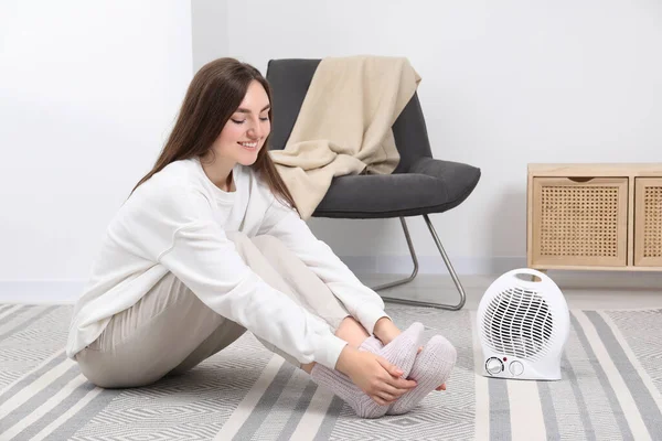 Mladá Žena Oteplování Nohy Blízkosti Elektrický Ventilátor Topení Doma — Stock fotografie