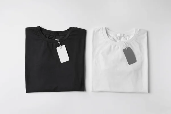 Stijlvolle Shirts Met Labels Witte Achtergrond Bovenaanzicht — Stockfoto