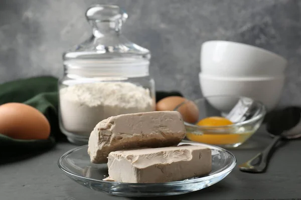 stock image Compressed yeast, eggs and flour on grey table