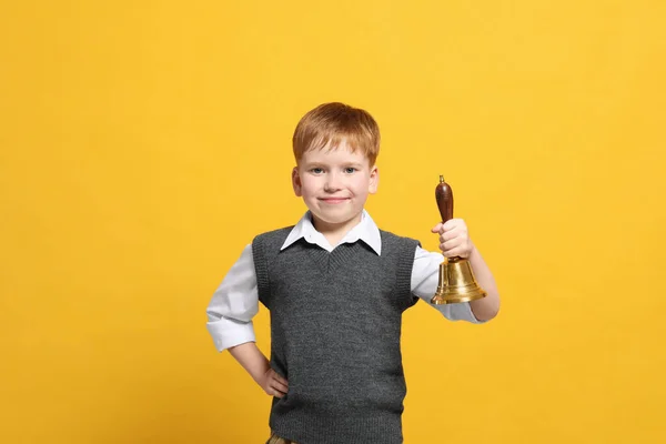 Pupil with school bell on orange background