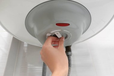 Kadın içeride maksimum enerji verimliliği göstergesi ayarlıyor, yakın plan. Kazan kurulumu