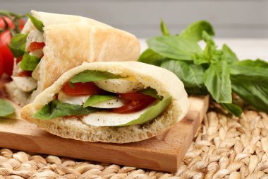 Mozzarella, domates ve hasır üzerine fesleğen ile nefis pita sandviçleri.