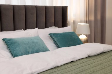 Odasında yatak ve lamba olan rahat bir yatak.