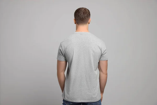 Man Wearing Blank Shirt Light Grey Background Back View Mockup — Stockfoto