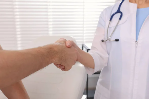 医者は診療所で患者と握手をして — ストック写真