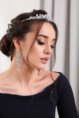 İçerde lüks bir taç takan güzel bir genç kadın.