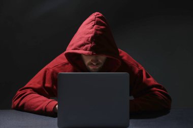 Hacker karanlık odada dizüstü bilgisayarla çalışıyor. Siber saldırı
