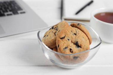 Ofisteki beyaz tahta masada çikolatalı kurabiyeler, yakın plan.