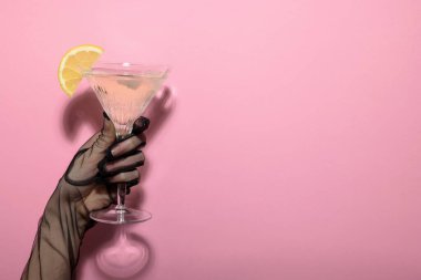 Elinde taze limon dilimli martini bardağı tutan bir kadın, yakın plan. Metin için boşluk