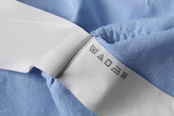 Clothing labels on light blue garment, closeup