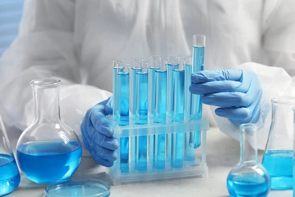 Wissenschaftler Nimmt Reagenzglas Mit Hellblauer Flüssigkeit Weißem Tisch Labor Nahaufnahme — Stockfoto