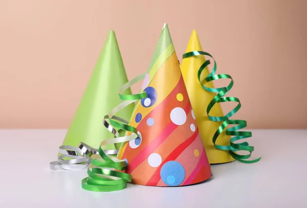 五颜六色的党帽和白色桌子上的彩带 生日庆祝活动 — 图库照片