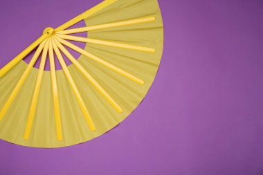 Mor arka planda parlak sarı el yelpaze, üst manzara. Metin için boşluk