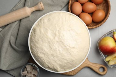 Taze hamur, merdane ve malzemeler gri masada, düz yerde. Maya keki pişiriyorum.