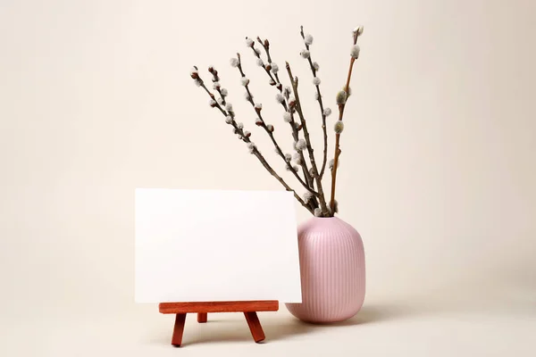 ベージュの背景に美しい開花柳の枝とスタンド上の空白のカードで花瓶 テキストのスペース — ストック写真