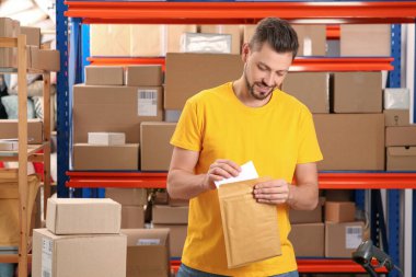 Postane çalışanı zarfı kapalı bir yere koyuyor.