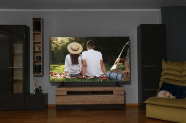 Televizyonda romantik bir film var, rahat bir odada.