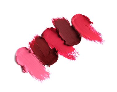 Smears of bright lipsticks on white background, top view