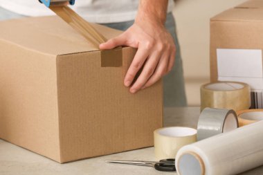 Kapalı mekanda yapıştırıcı bantlı bir paket kutusu var.