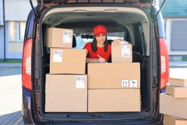 stock image Courier with clipboard checking packages in delivery van