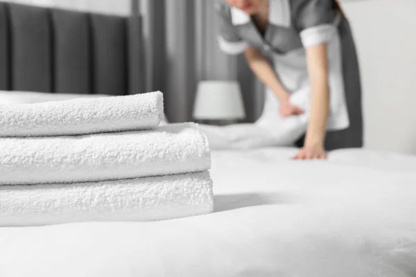 Otel Odasında Yatak Yapan Genç Hizmetçi Temiz Havlu Yığınına Odaklan — Stok fotoğraf