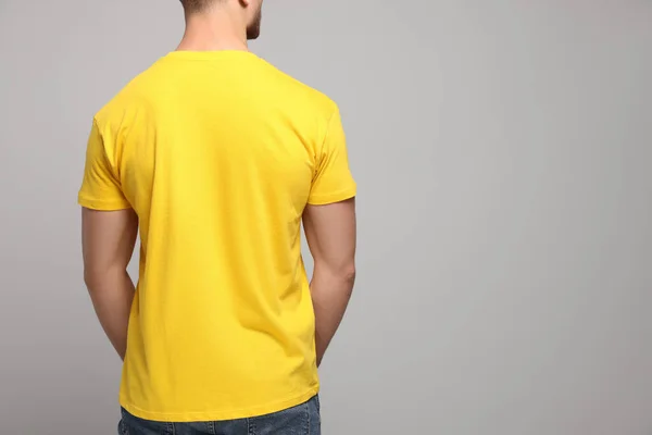 Homem Vestindo Camiseta Amarela Fundo Cinza Claro Vista Traseira Mockup — Fotografia de Stock