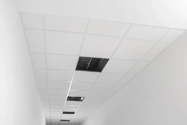 Low angle view on PVC tiles. Installing ceiling lighting