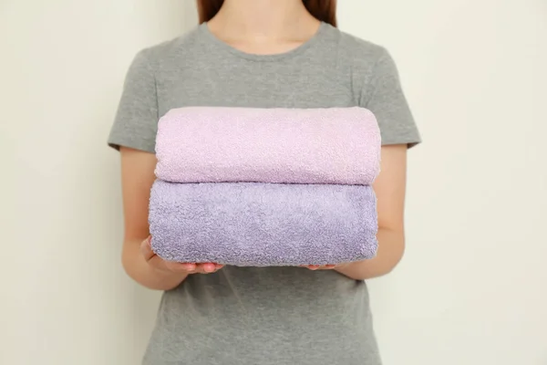 Woman Holding Folded Soft Terry Towels Light Background Closeup — Stock Photo, Image