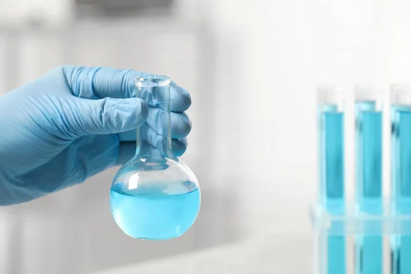 Scientist Holding Flask Light Blue Liquid Laboratory Closeup Space Text — Fotografia de Stock