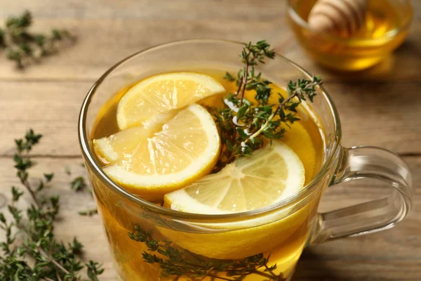 stock image Fresh thyme tea with pieces of lemon on table, closeup