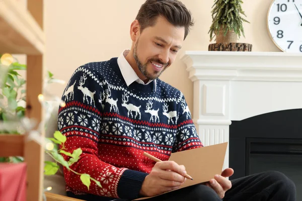 Šťastný Muž Psaní Přání Vánoční Přání Obývacím Pokoji — Stock fotografie
