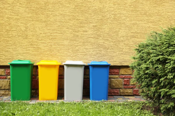 Many Colorful Recycling Bins Yellow Wall Outdoors — Stock Fotó