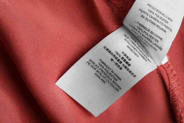 Clothing labels on beautiful garment, top view. Space for text