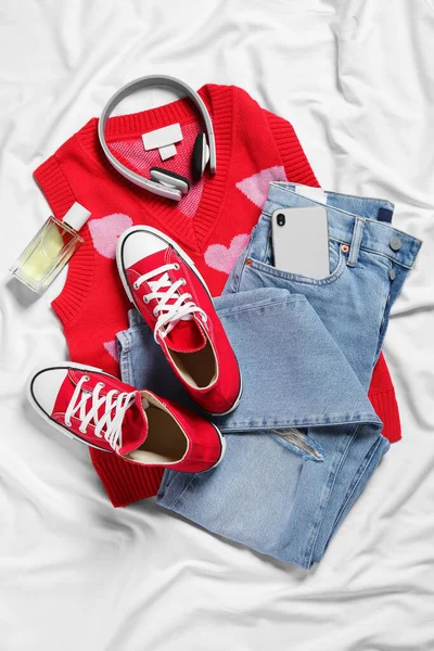 Ζεύγος Από Κομψά Κόκκινα Παπούτσια Ρούχα Και Smartphone Λευκό Ύφασμα — Φωτογραφία Αρχείου