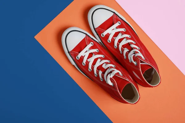 stock image Pair of new stylish red sneakers on colorful background, flat lay. Space for text