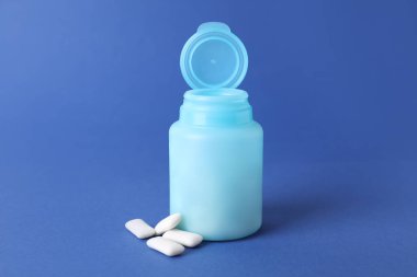 Mavi arkaplanda sakız çiğneyen kavanoz