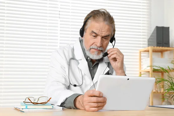 클리닉 나무로 책상에서 진료하는 태블릿 환자의 의사입니다 온라인 — 스톡 사진