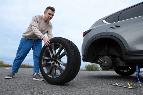 Young Man Changing Tire Car Roadside — 스톡 사진